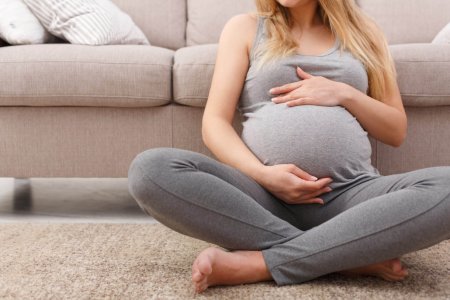 Unrecognizable pregnant woman caressing her belly