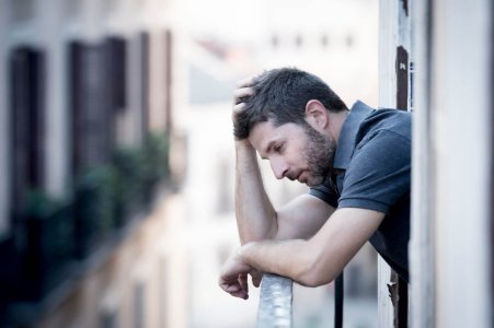 young man at balcony in depression suffering emotional crisis